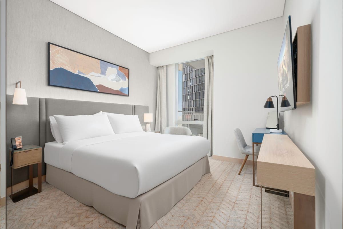 A large king size bed in a bright white bedroom
