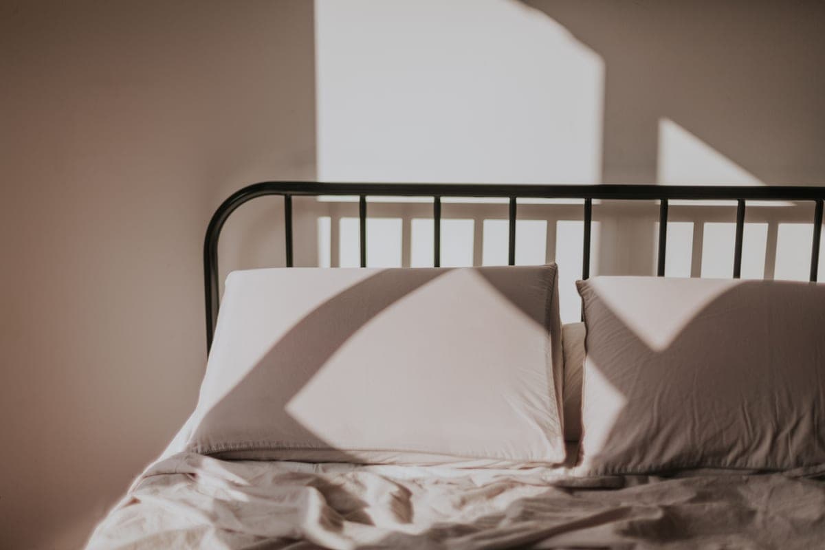 A bed with the fitted sheet pulled back at one corner
